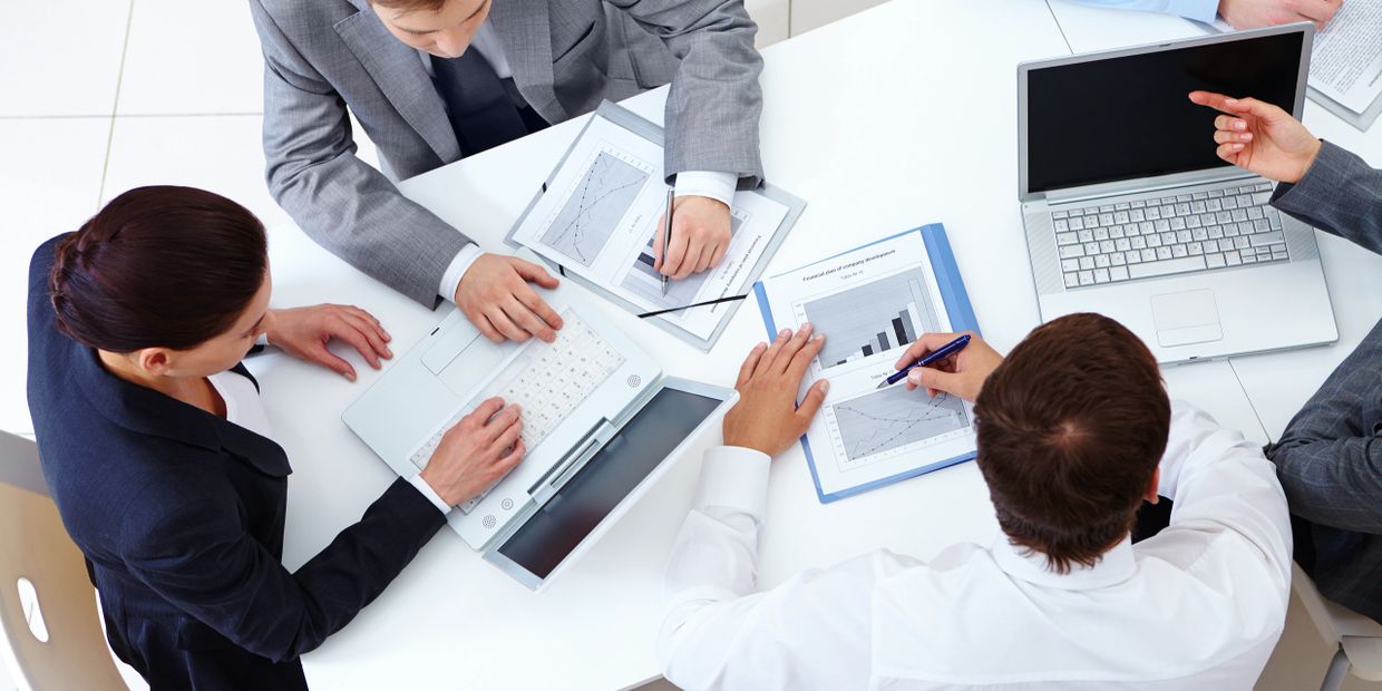 Above view of business team sitting around table and working